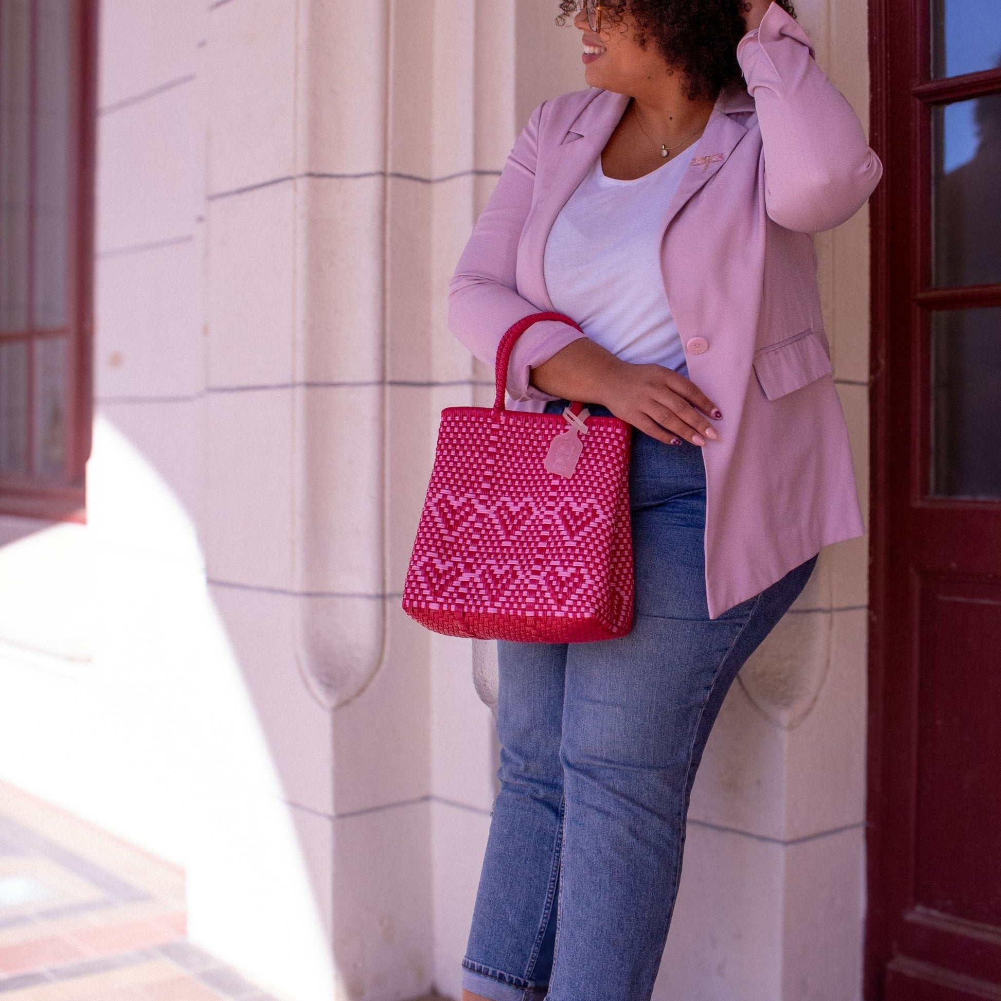 Le sac Chéri S Camélia, motif cœurs en rose et rouge, porté par Madie, au look vibrant.