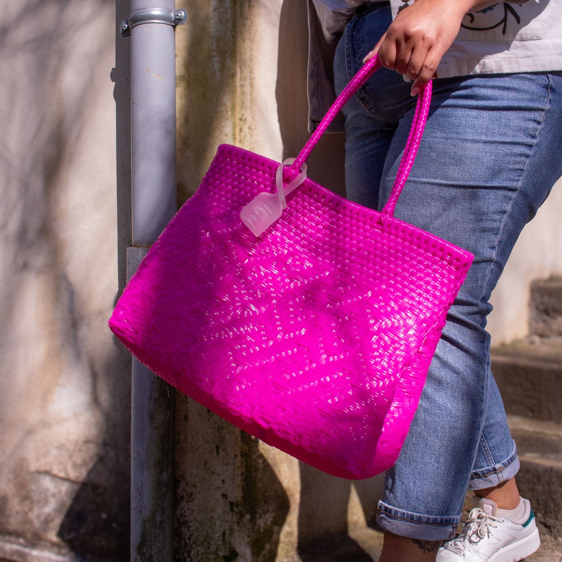 Plan rapproché du sac Loom M Bougainvillier, montrant son tressage en plastique recyclé et sa teinte rose.