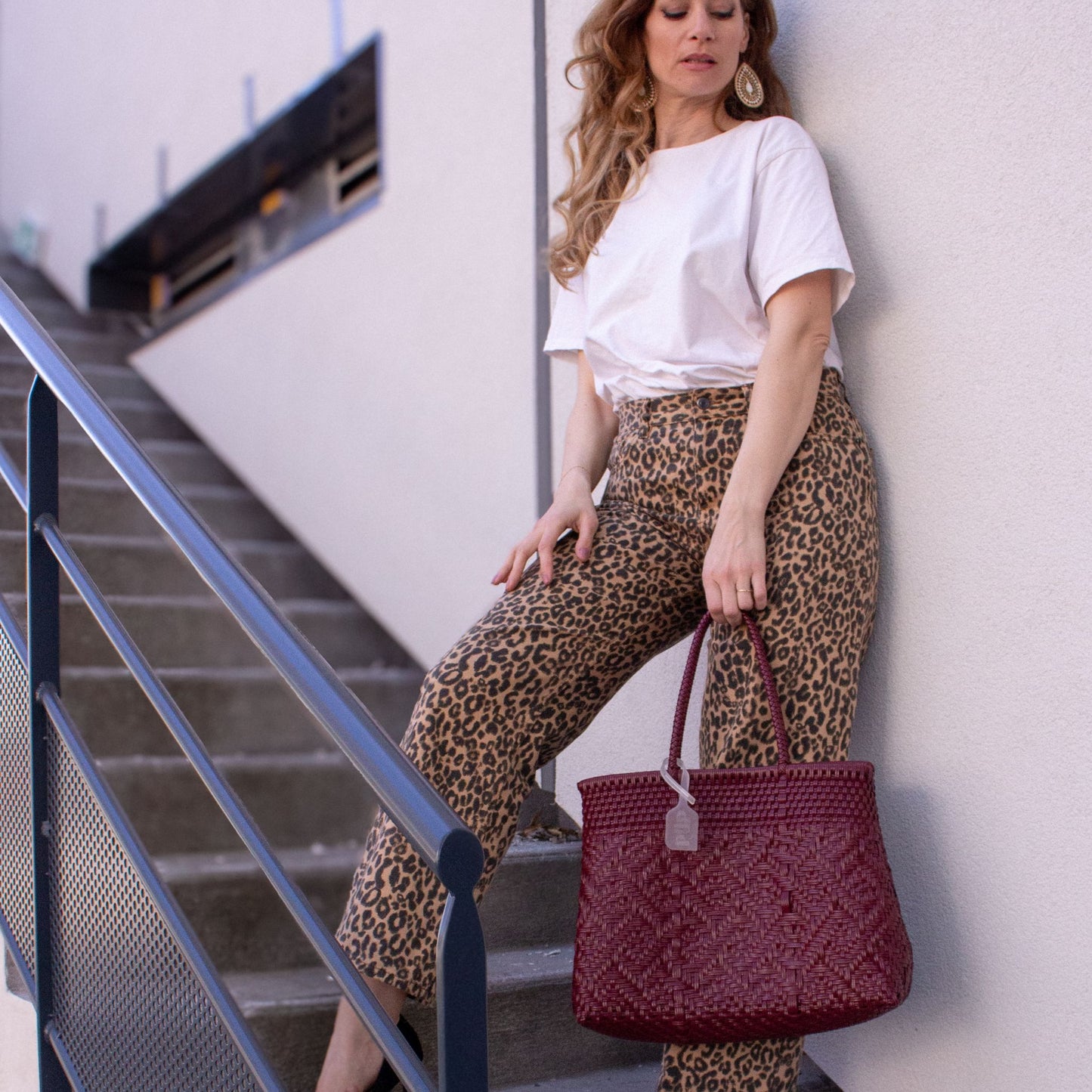 Emmanuelle  adopte le sac Loom M Lie de Vin, bordeaux, tressé en plastique recyclé.