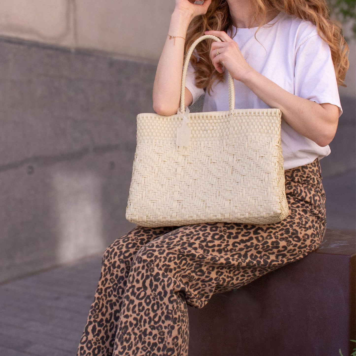 Plan rapproché du sac Loom M Lin, mettant en valeur son tressage en plastique recyclé, coloris naturel.