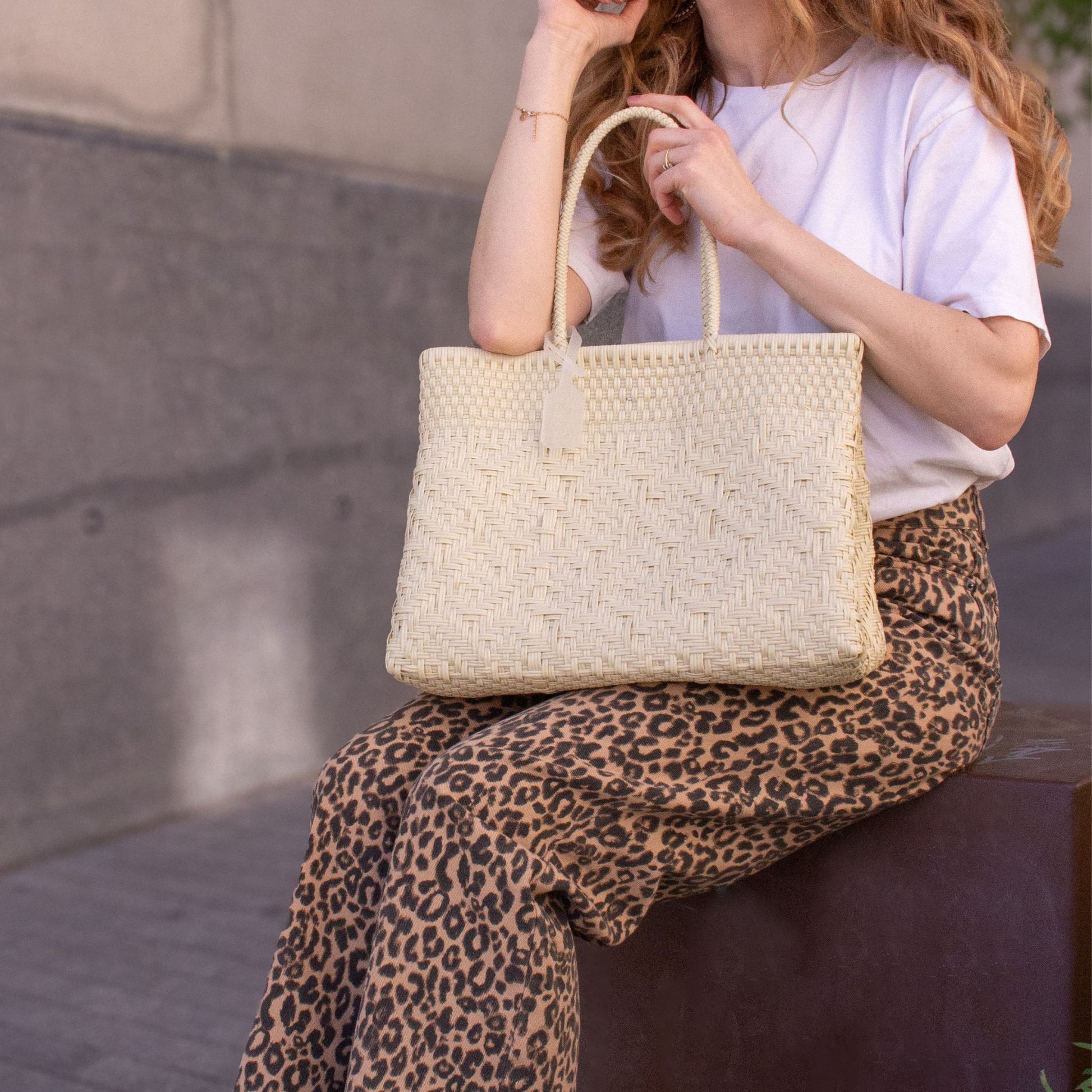 Plan rapproché du sac Loom M Lin, mettant en valeur son tressage en plastique recyclé, coloris naturel.