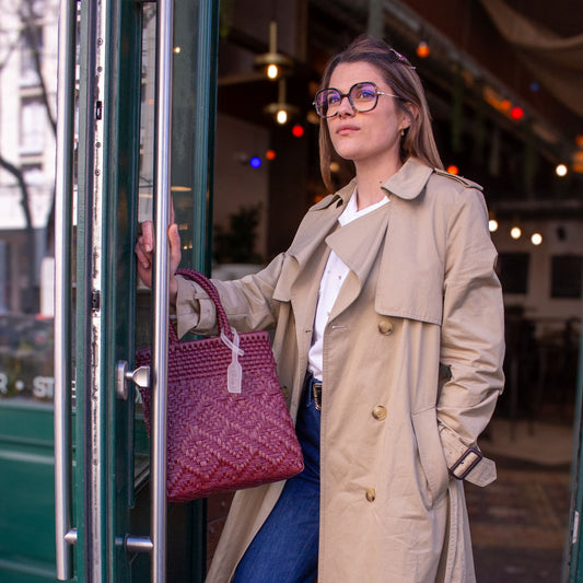 Anna porte le sac Loom S Lie de Vin, tressé en plastique recyclé, dans une élégante nuance bordeaux.