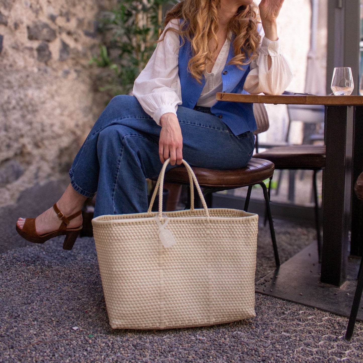 Emmanuelle tient le panier Maxi Lin en plastique recyclé, tressé dans un ton lin naturel, texture artisanale.