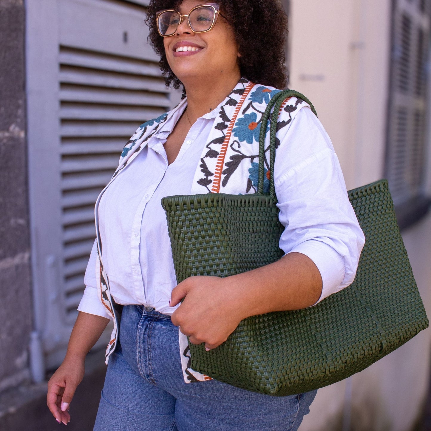 Vue portée du panier Maxi Olive, à l’épaule de Madie, au format généreux et à la couleur végétale.
