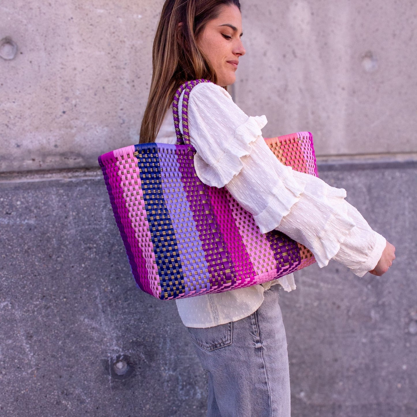 Panier Medium Vespera porté à l’épaule d'Anna, tons doux de rose et violet.