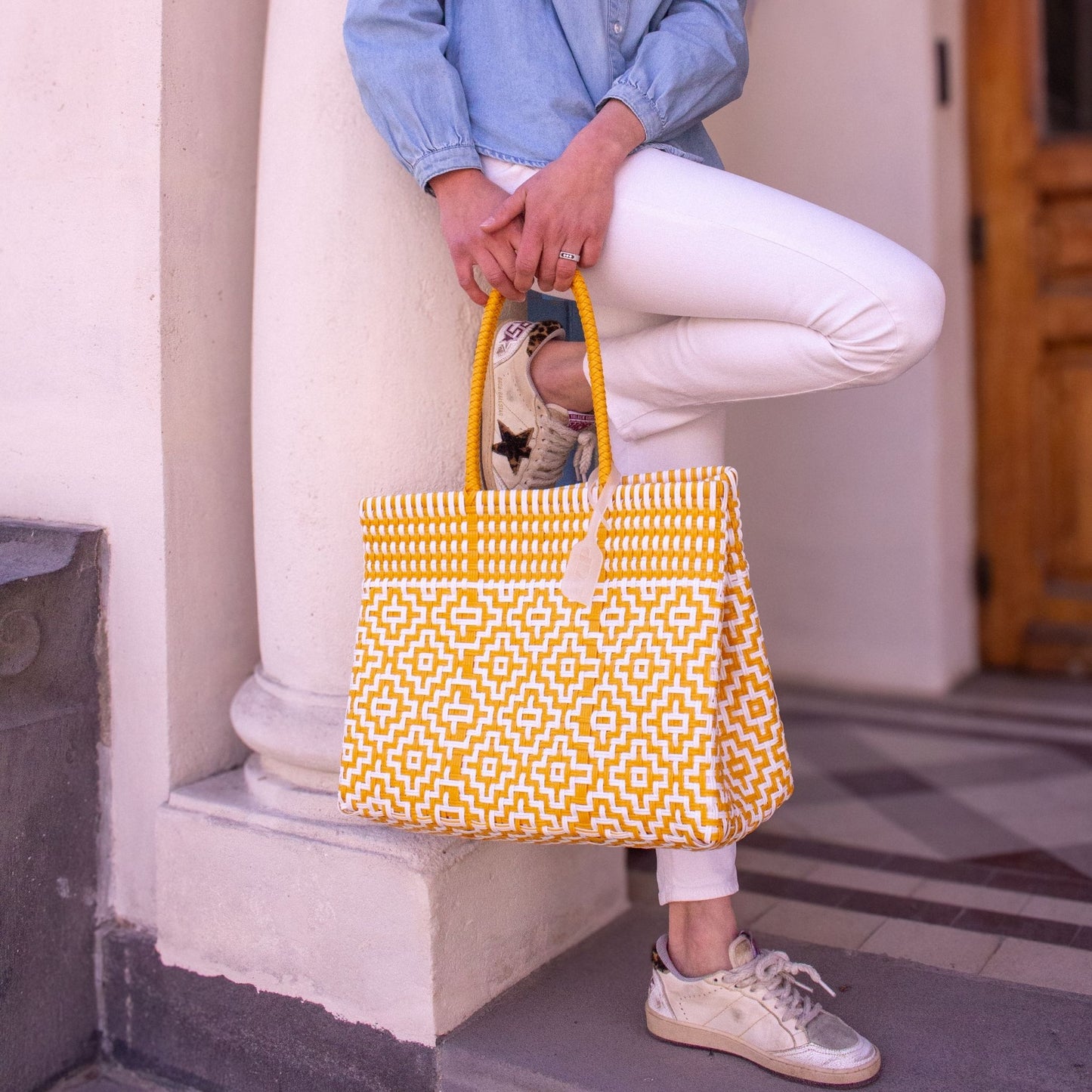 Anna sublime sa tenue avec le sac Mosaïc M Aurore, tressé en plastique recyclé, blanc et jaune.