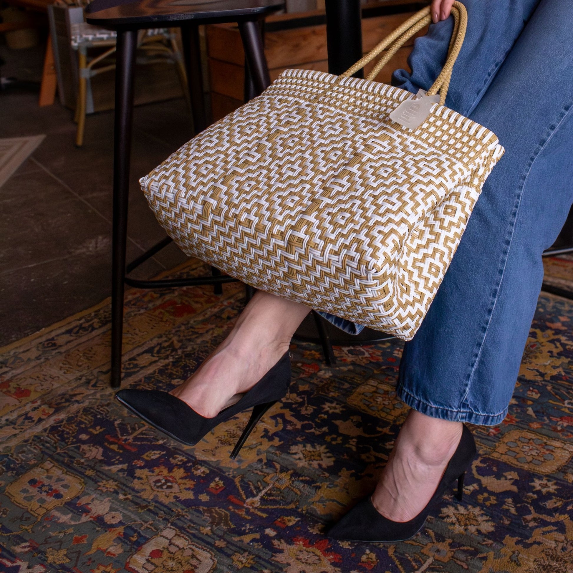 Plan rapproché sur le sac Mosaïc M Dune, mettant en valeur son tressage blanc et beige.