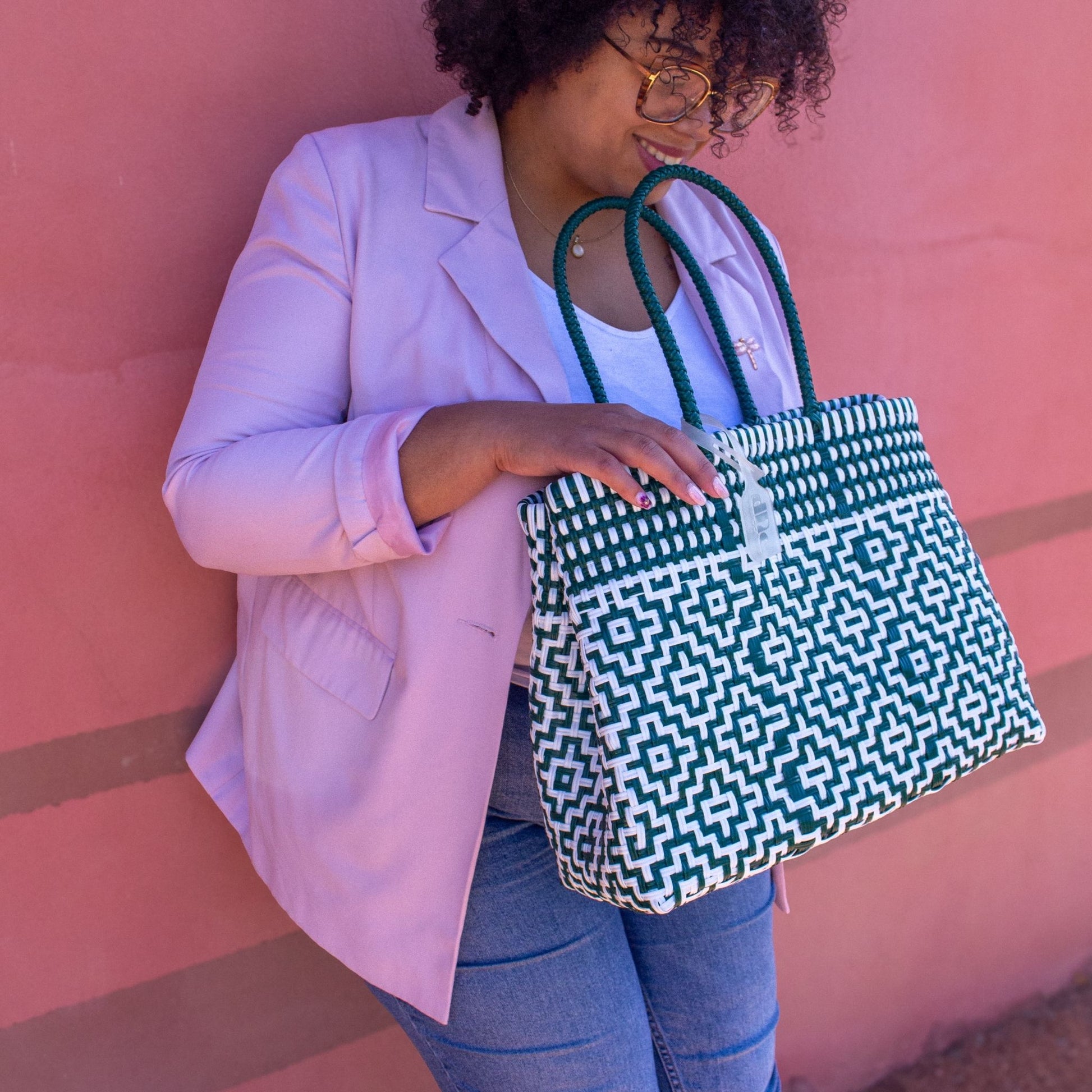 Madie choisit le sac Mosaïc M Jade, tressé en plastique recyclé, aux nuances blanc et vert, pour une allure douce et moderne.