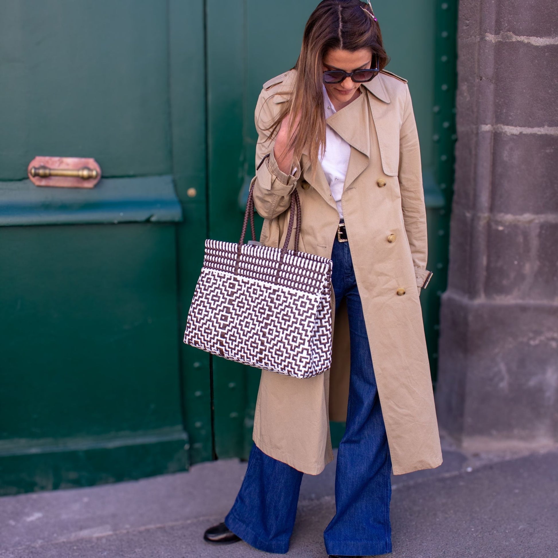 Anna mise sur le sac Mosaïc M Moka, tressé en plastique recyclé, blanc et marron, pour compléter sa tenue.