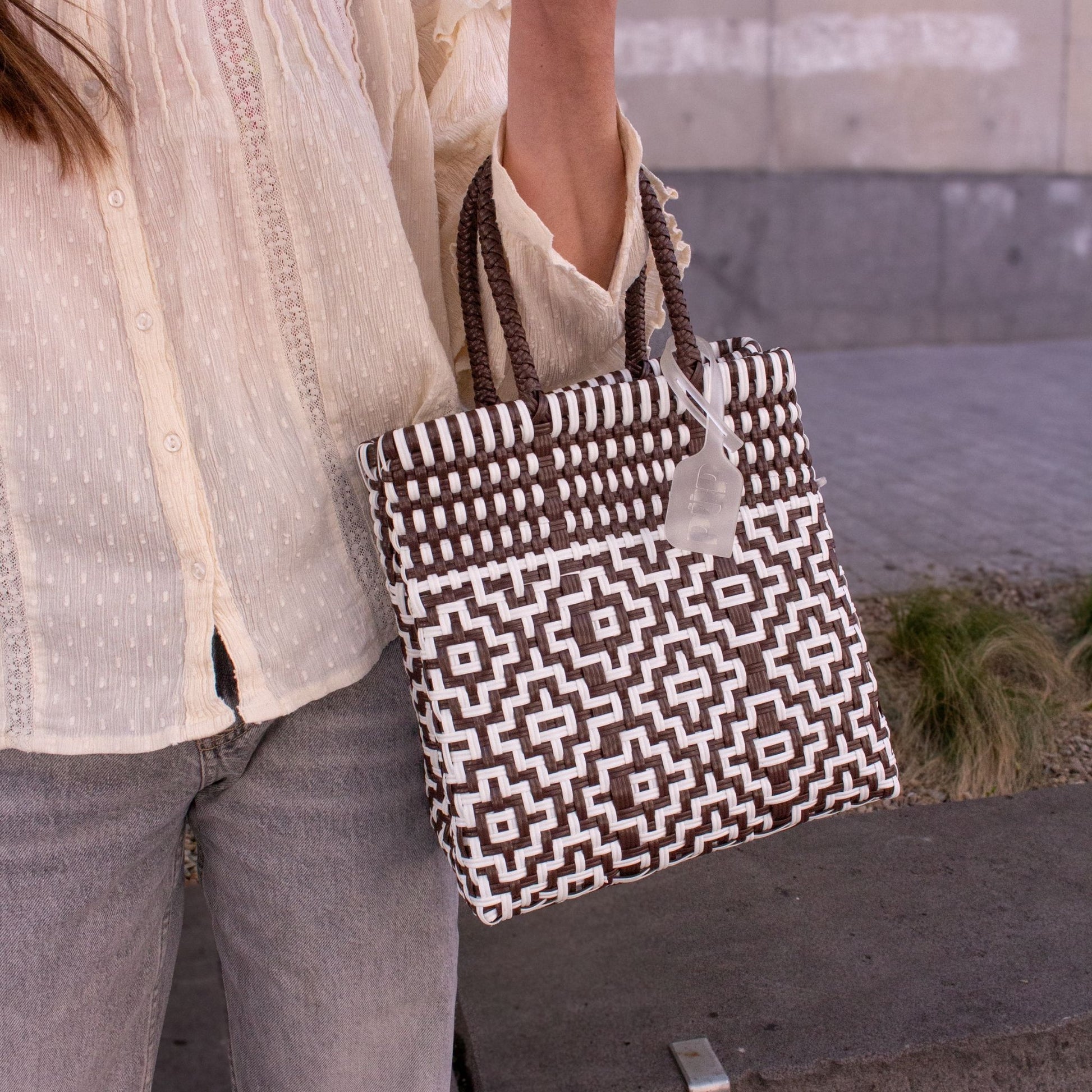 Plan rapproché du sac Mosaïc S Moka, mettant en valeur son tressage contrasté en blanc et marron.