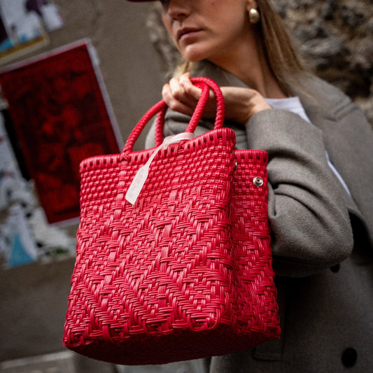 Clémentine porte le sac à main Loom S dans le coloris Cerise