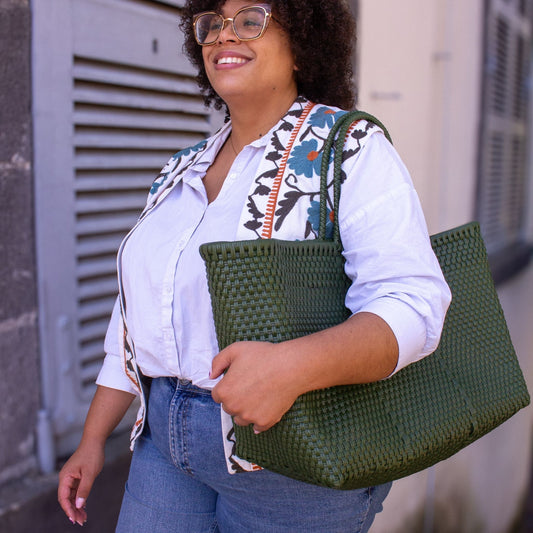 Vue portée du panier Maxi Olive, à l’épaule de Madie, au format généreux et à la couleur végétale.