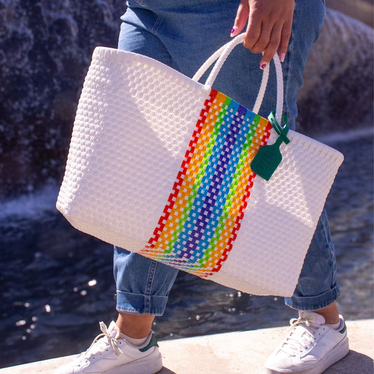 Panier Medium Prisme en plastique recyclé, fond blanc avec bande multicolore arc-en-ciel.
