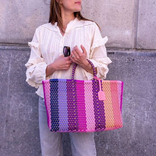 Vue du panier Medium Vespera porté par Anna, tressage en plastique recyclé aux nuances violettes et rosées.